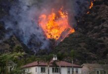 Wildfire burning on a hillside near homes