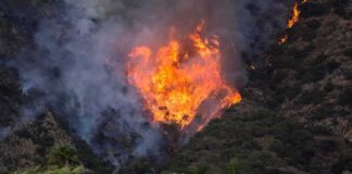 Wildfire burning on a hillside near homes