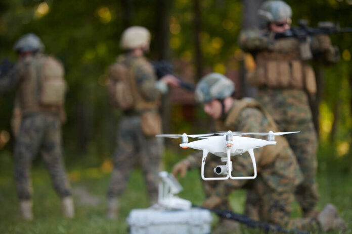 Modern,Warfare,Soldiers,Squad,Are,Using,Drone,For,Scouting,And A military drone being prepared for use with soldiers in the background