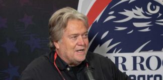 man speaking into a microphone at an event booth
