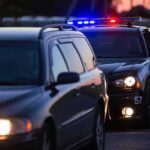 Questions Follow Officer-Involved Alleyway Collision Police car with flashing lights behind a stopped vehicle at dusk