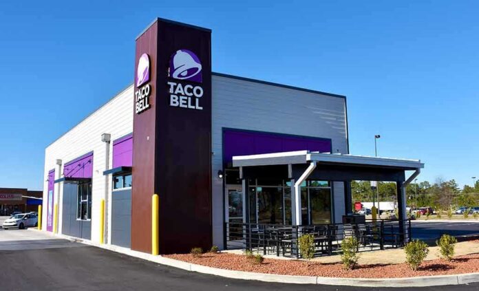 shutterstock_2254889225 Taco Bell restaurant exterior with drive-thru and patio seating