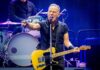 Rock Legends Clash Over Politics On Stage A musician passionately performing on stage with a guitar