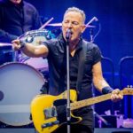Rock Legends Clash Over Politics On Stage A musician passionately performing on stage with a guitar