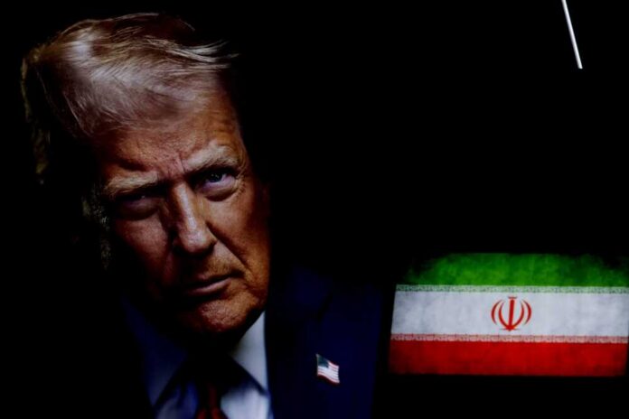 Close-up portrait of a man with a serious expression, with the Iranian flag in the background