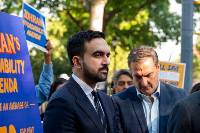 Democratic,New,York,City,Mayoral,Candidate,Zohran,Mamdani,Launches,A Man in suit speaking at outdoor press event with signs in background
