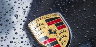Porsche crest on wet car hood