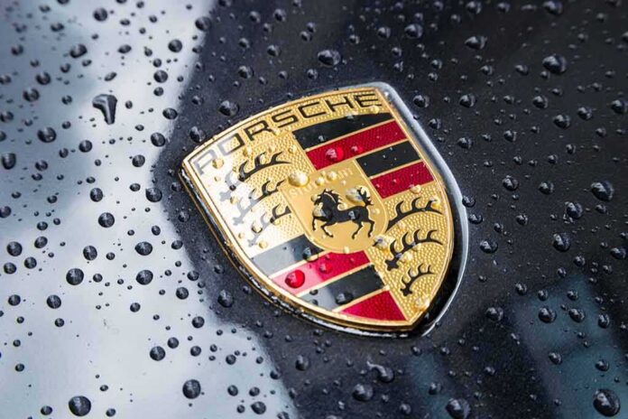 Porsche crest on wet car hood