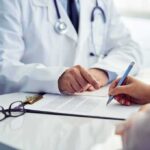 doctor and patient reviewing and signing medical form