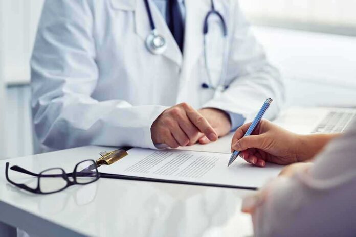 doctor and patient reviewing and signing medical form