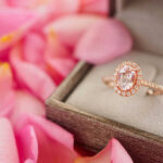 Rose gold halo ring in a jewelry box among pink petals