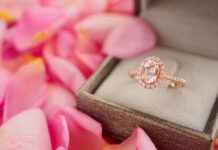 Rose gold halo ring in a jewelry box among pink petals
