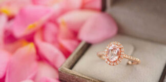 Rose gold halo ring in a jewelry box among pink petals