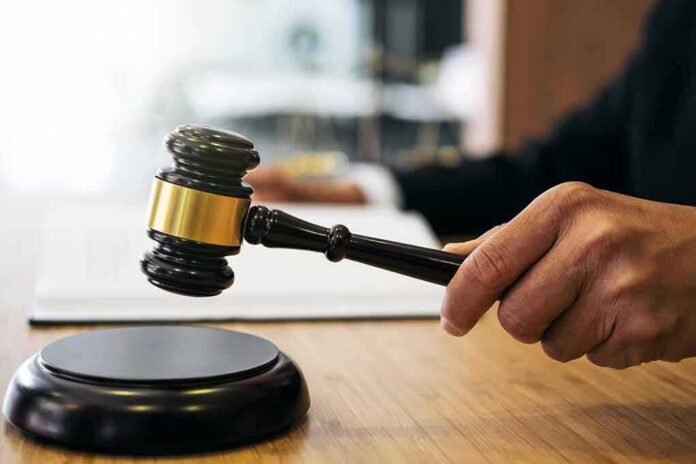 Judge's hand holding a gavel over a sound block