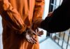 Sacramento’s Parole Change Is Raising Eyebrows Prisoner in orange jumpsuit handcuffed by officer