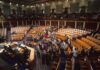 Legislative chamber with members gathering on the floor