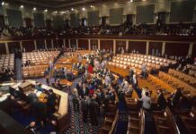 Legislative chamber with members gathering on the floor