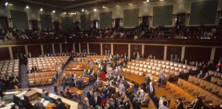 Legislative chamber with members gathering on the floor