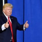 Trump Stops Mid-Speech, Then Flips the Script man in suit giving two thumbs up