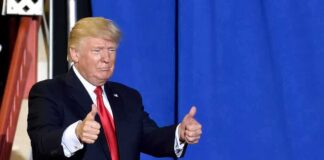 man in suit giving two thumbs up