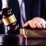 Guilty Plea Fight Reopens Idaho Murder Case Judge's gavel striking block with hand on book in background