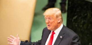 speaker in suit gestures at podium