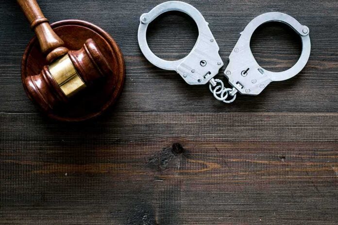 Gavel and handcuffs on wooden table