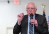 Bernie Wants America to Hit AI’s Brakes Elderly man speaking into a microphone