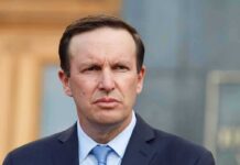Dem Senator Turns Politics Into a Spiritual Diagnosis Man in suit and tie outdoors with serious expression