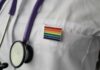 A Healthcare Promise With No Age Line stethoscope on white lab coat with rainbow pin