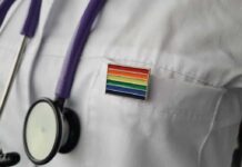 A Healthcare Promise With No Age Line stethoscope on white lab coat with rainbow pin