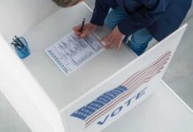 One Checked Box Lands A Registrant In Trouble Voter filling out a ballot in a private voting booth