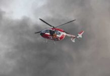 Rescue helicopter hovers amid thick smoke
