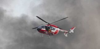 Rescue helicopter hovers amid thick smoke
