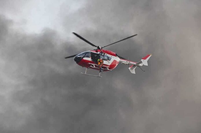 Rescue helicopter hovers amid thick smoke