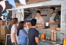 Thousands Of Complaints Expose A Sidewalk Food Crisis food truck staff serve drinks to customers at window