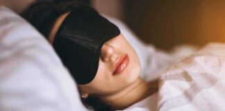 Woman sleeping with a black eye mask in bed