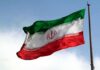 Tehran Says The Next Move Isn’t Theirs Iranian flag waving on a pole