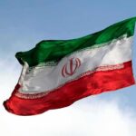 Tehran Says The Next Move Isn’t Theirs Iranian flag waving on a pole