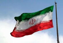 Tehran Says The Next Move Isn’t Theirs Iranian flag waving on a pole