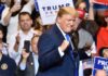 GOP’s Unusual Midterm Experiment Ends in Dallas man in suit raising fists at a rally podium
