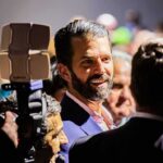 The Investment Mystery Congress Wants To Crack man with beard in suit speaking to people at crowded event