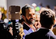 The Investment Mystery Congress Wants To Crack man with beard in suit speaking to people at crowded event