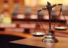 Immunity Shattered: Trial Greenlit for Brawl bronze balance scales on a courtroom desk