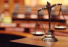 Immunity Shattered: Trial Greenlit for Brawl bronze balance scales on a courtroom desk