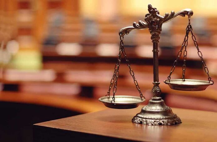 shutterstock_140867215 bronze balance scales on a courtroom desk