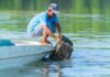 Biden Barriers Smashed – Outdoors Reopened Fisherman retrieving a crab trap from the water beside a small boat