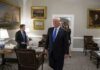 Donald Trump walks through an office with Sean Lawler nearby and Mariano Rajoy following behind