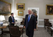 Donald Trump walks through an office with Sean Lawler nearby and Mariano Rajoy following behind