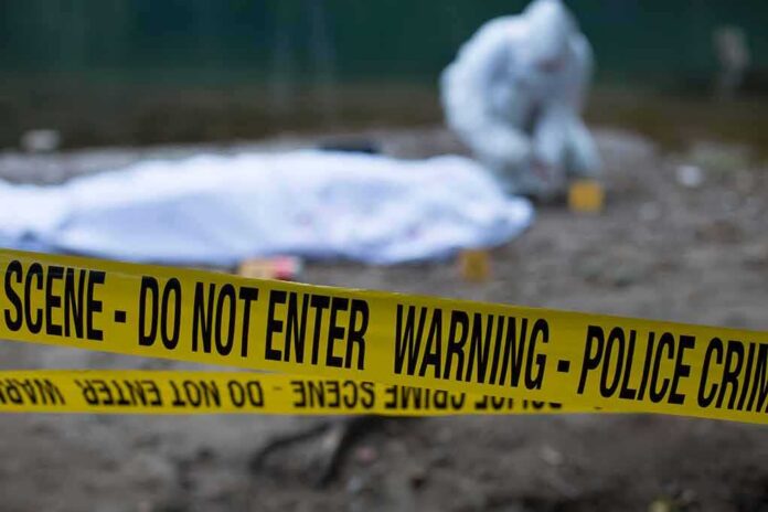 shutterstock_1474746275 Crime scene with police tape and forensic investigator